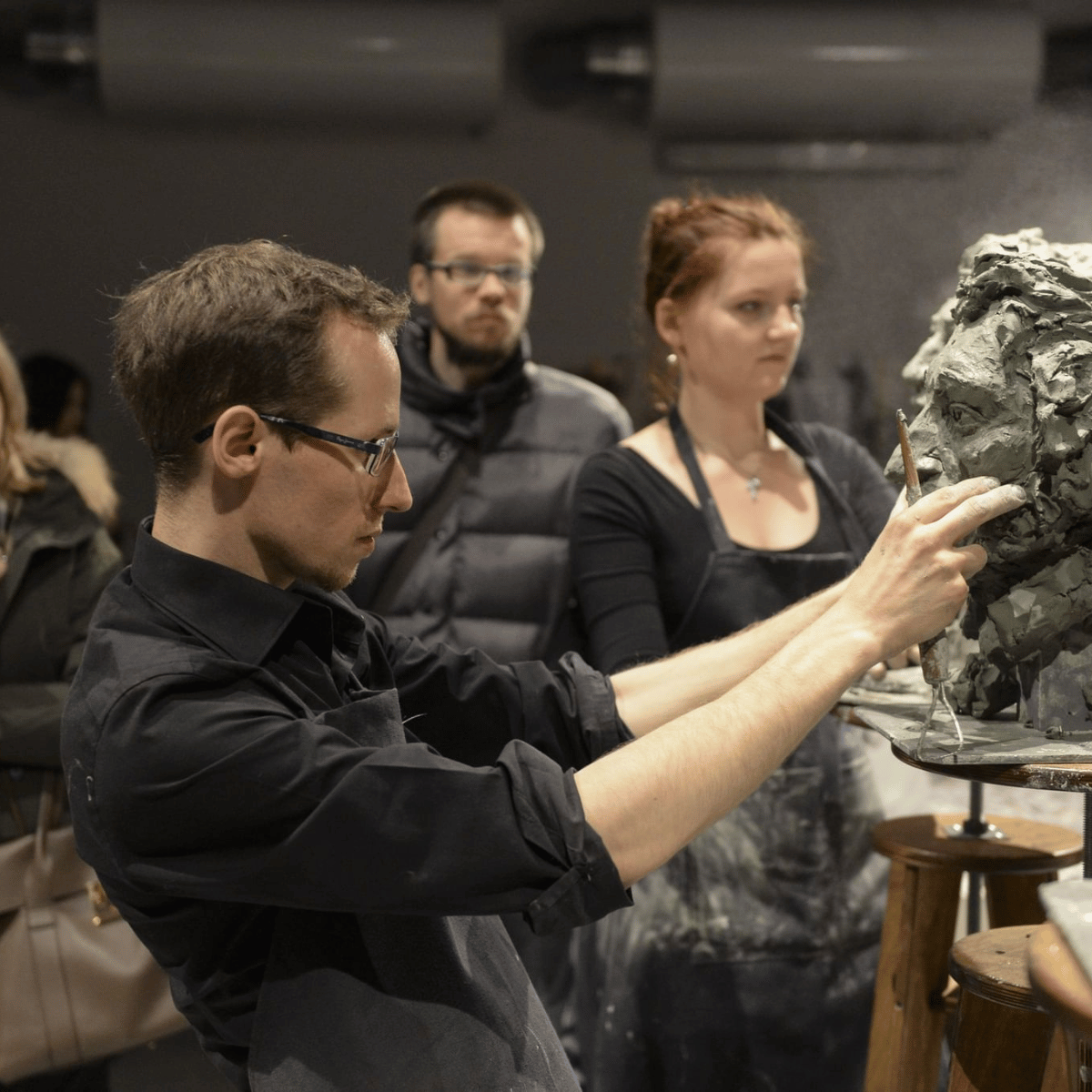 Clase de escultura con estudiante modelando arcilla